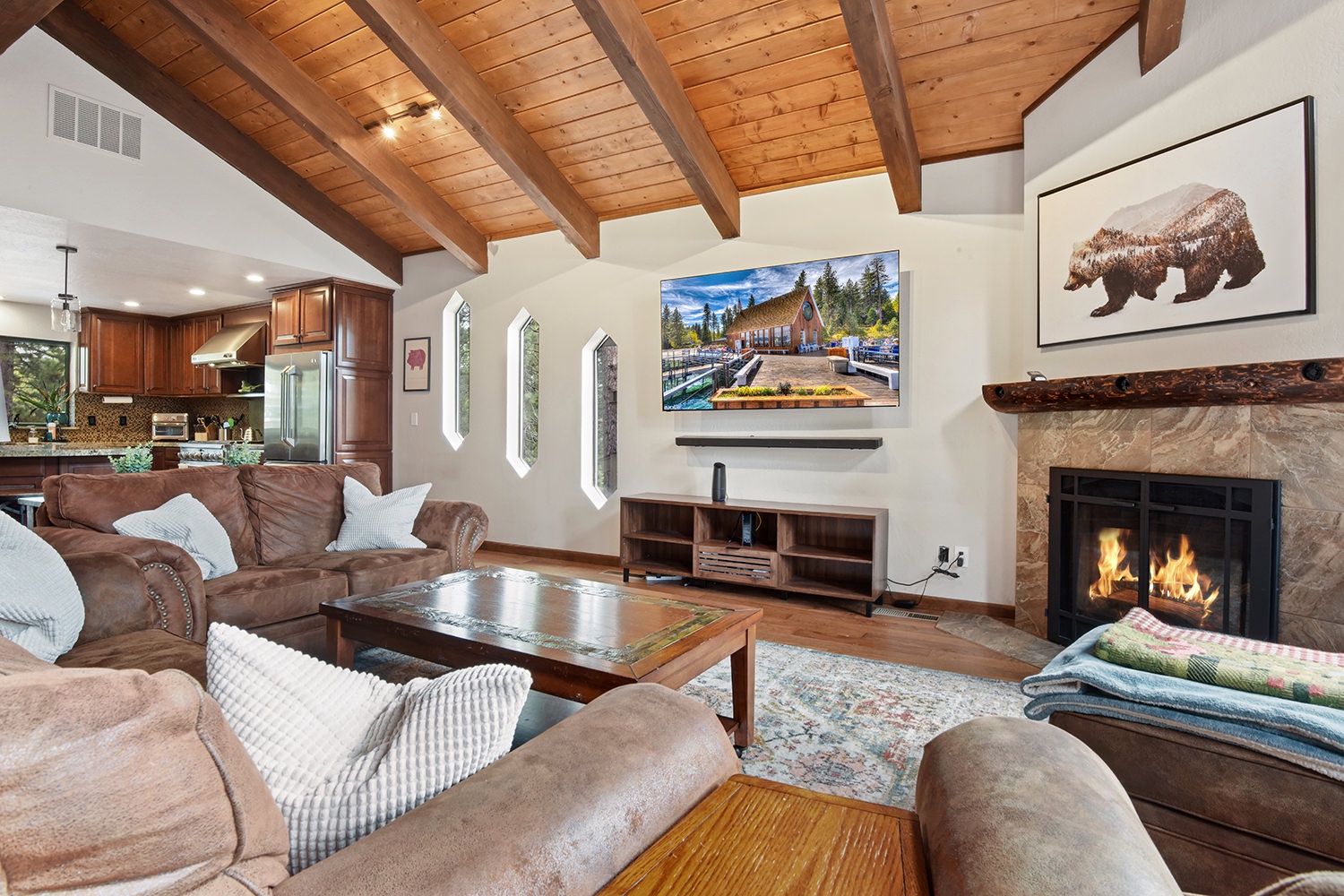 Large open living space with TV, fireplace, and deck access