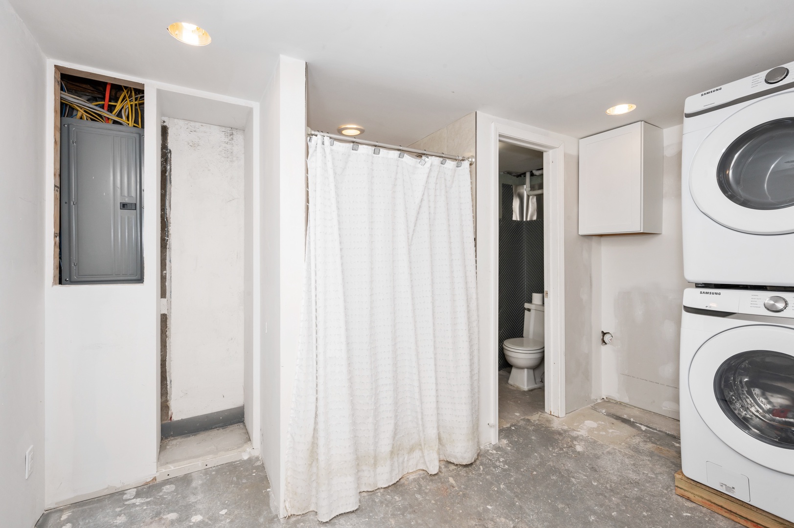 Private laundry is tucked away in the lower-level full bath, offering a shower
