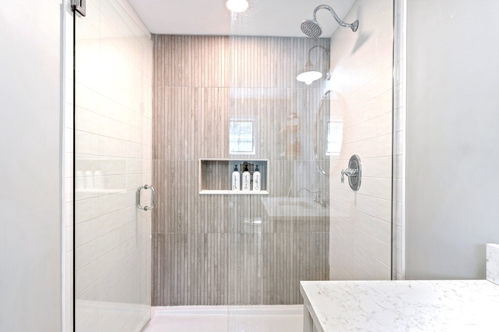 The ensuite features a luxurious spa-like glass walk-in shower