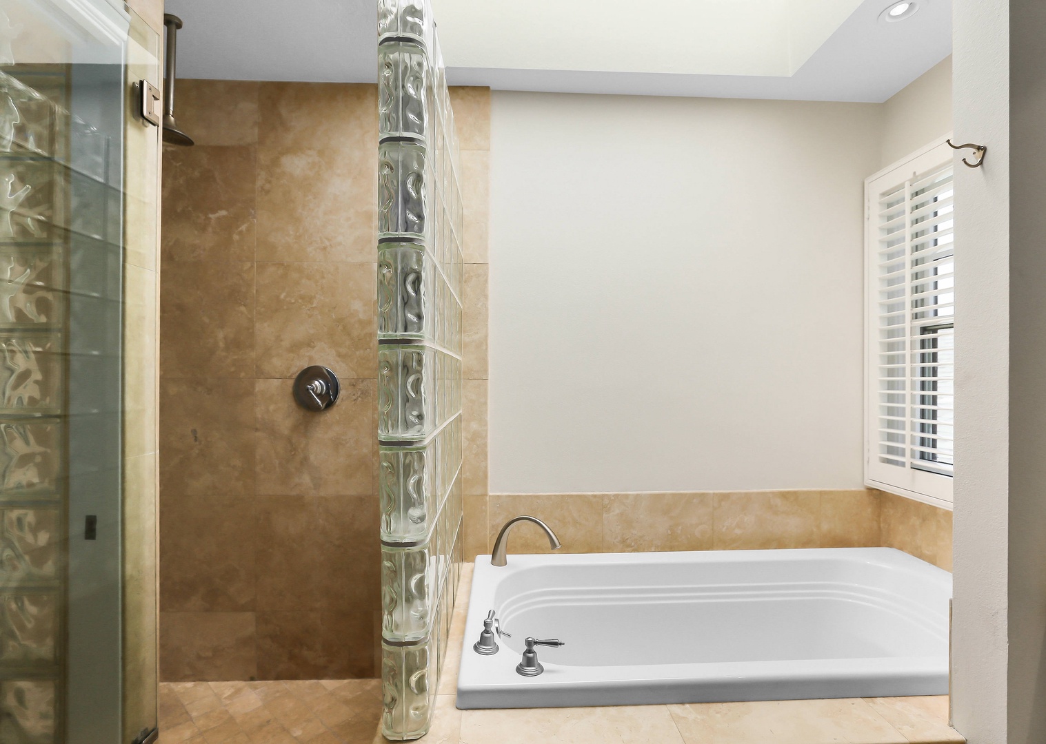 En suite bathroom with dual sinks, soaking tub and standing shower