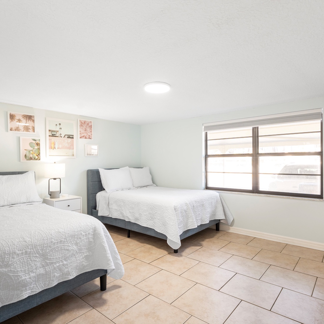 The second bedroom offers a pair of full-sized beds & Smart TV