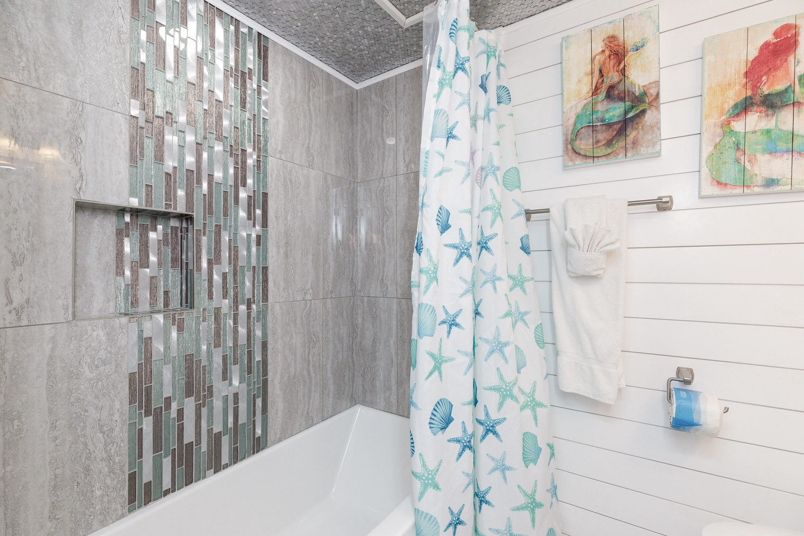 This en suite bathroom includes a single vanity & shower/tub combo