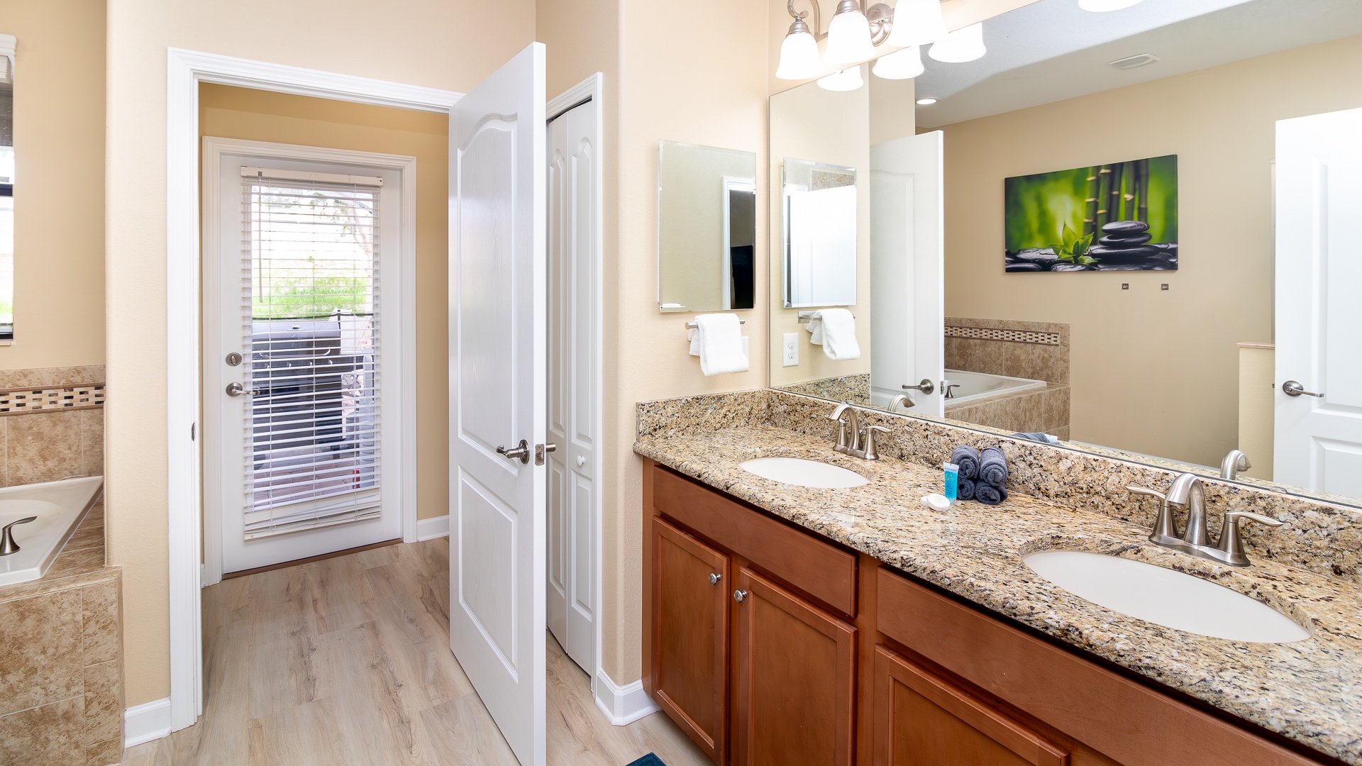 This ensuite bath features a double vanity, glass shower, & soaking tub