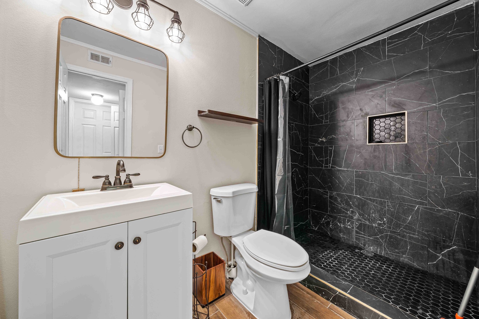 A single vanity, walk-in shower await in the ensuite bath