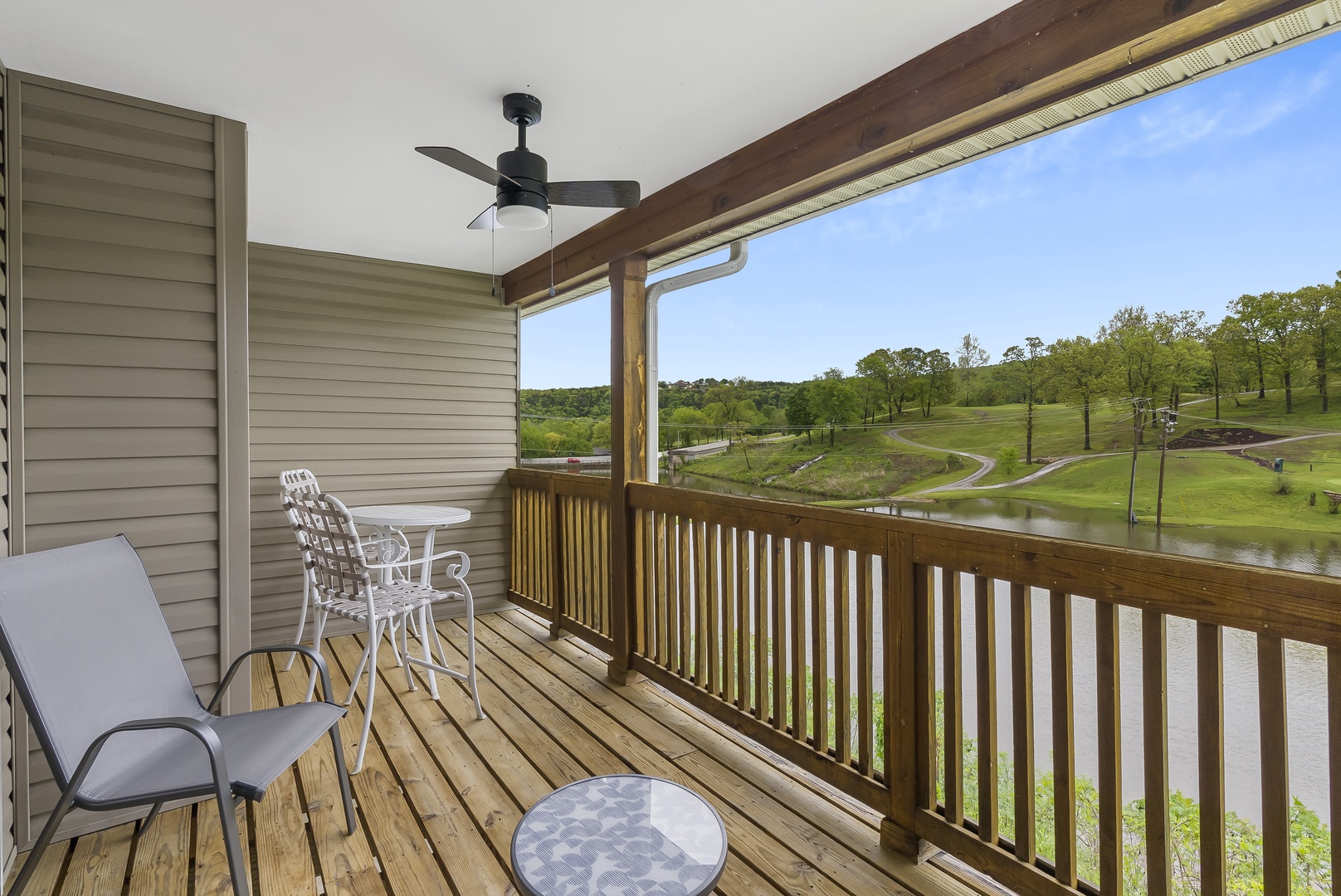 Balcony with outdoor seating, lake, and golf course view