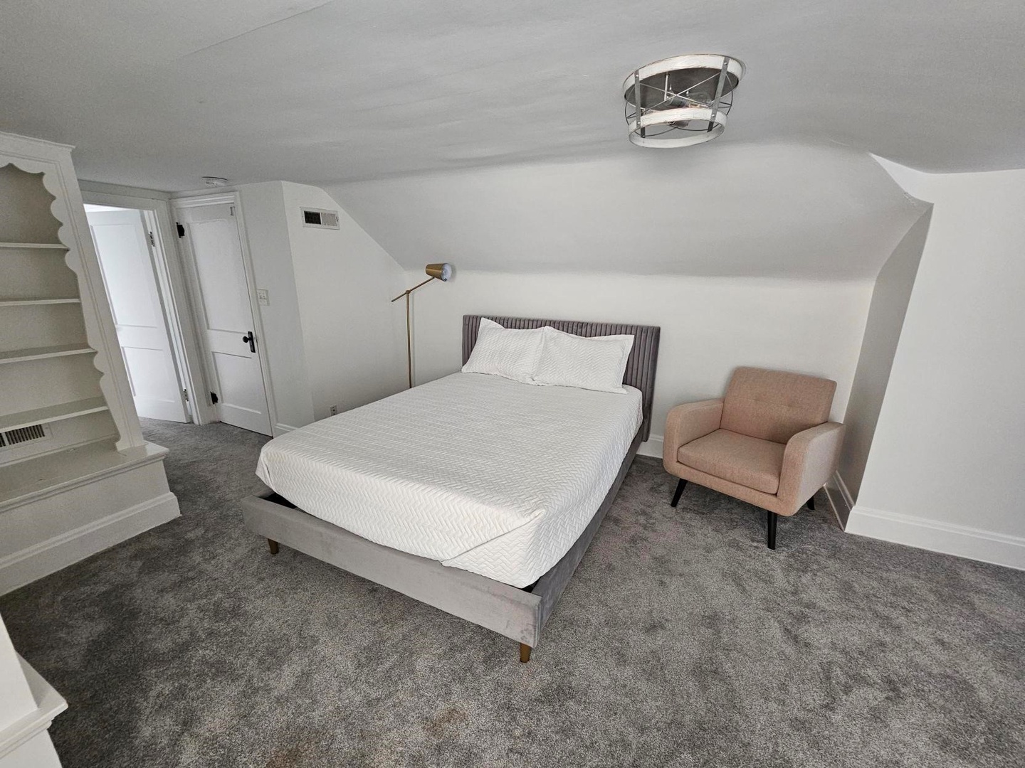 Unit 2 – The 3rd floor attic bedroom area includes a cozy queen bed & armchair