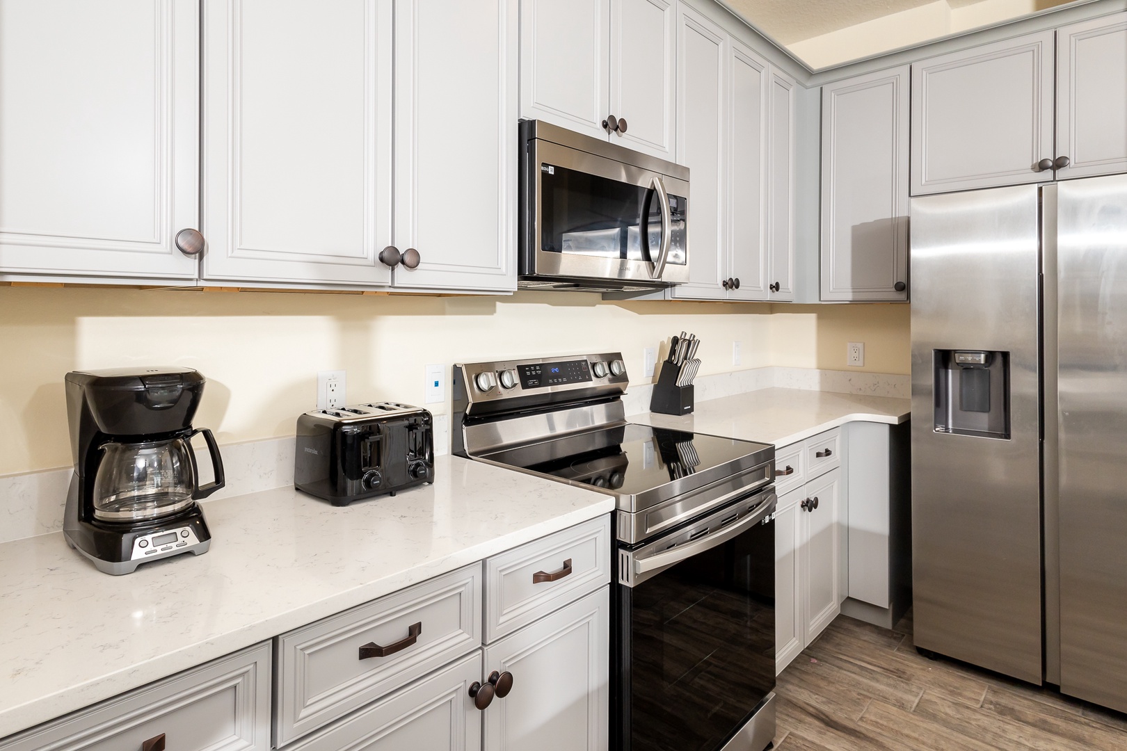 The sleek kitchen offers ample storage space & all the comforts of home