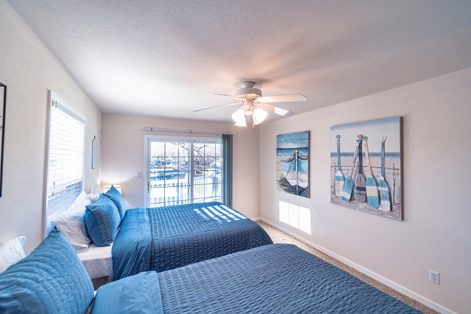 The second upper-level bedroom offers a pair of queen beds & deck access