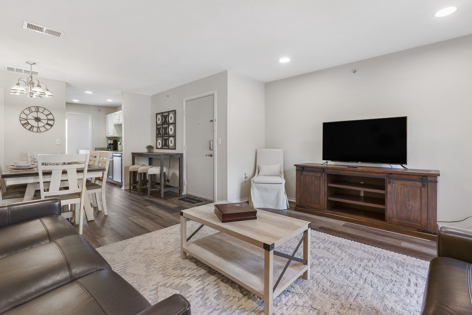 Open living space with ample seating, Smart TV, and balcony access