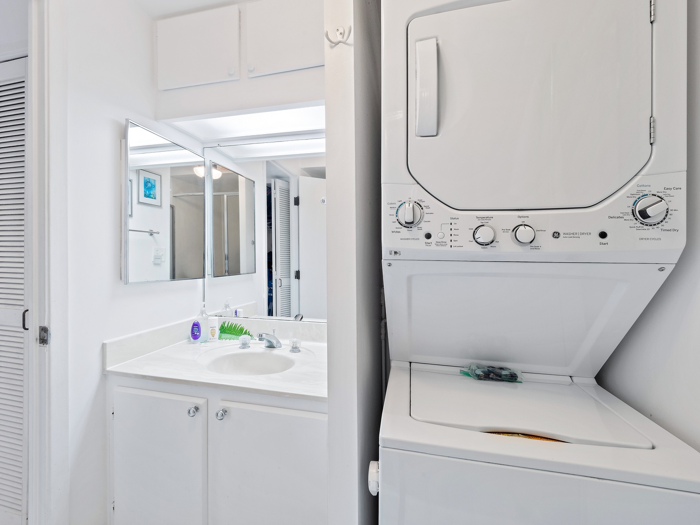 Shared bathroom with stand up shower, and stacked washer and dryer