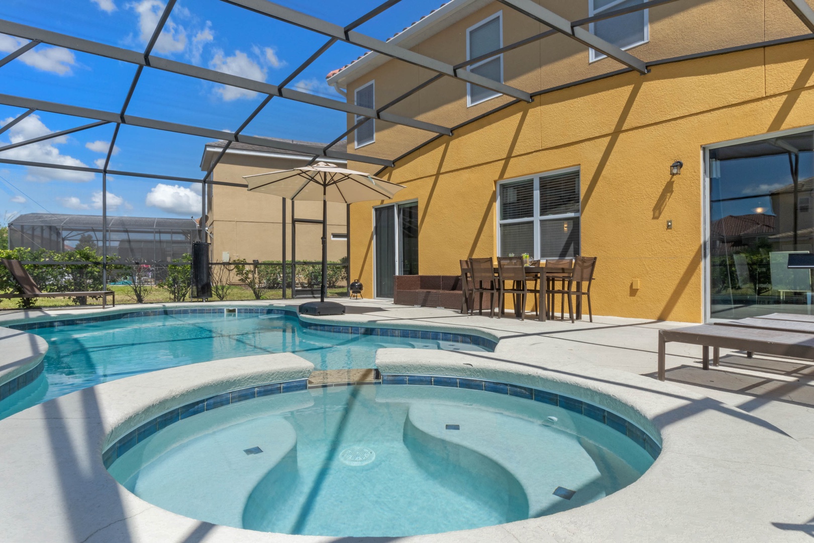 Private screened pool area with pool, hot tub, and outdoor seating