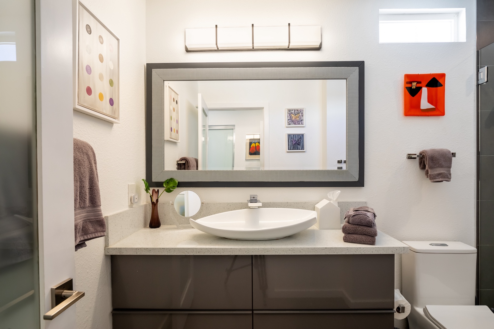 The polished primary king en suite boasts an oversized vanity & spa-like rain shower