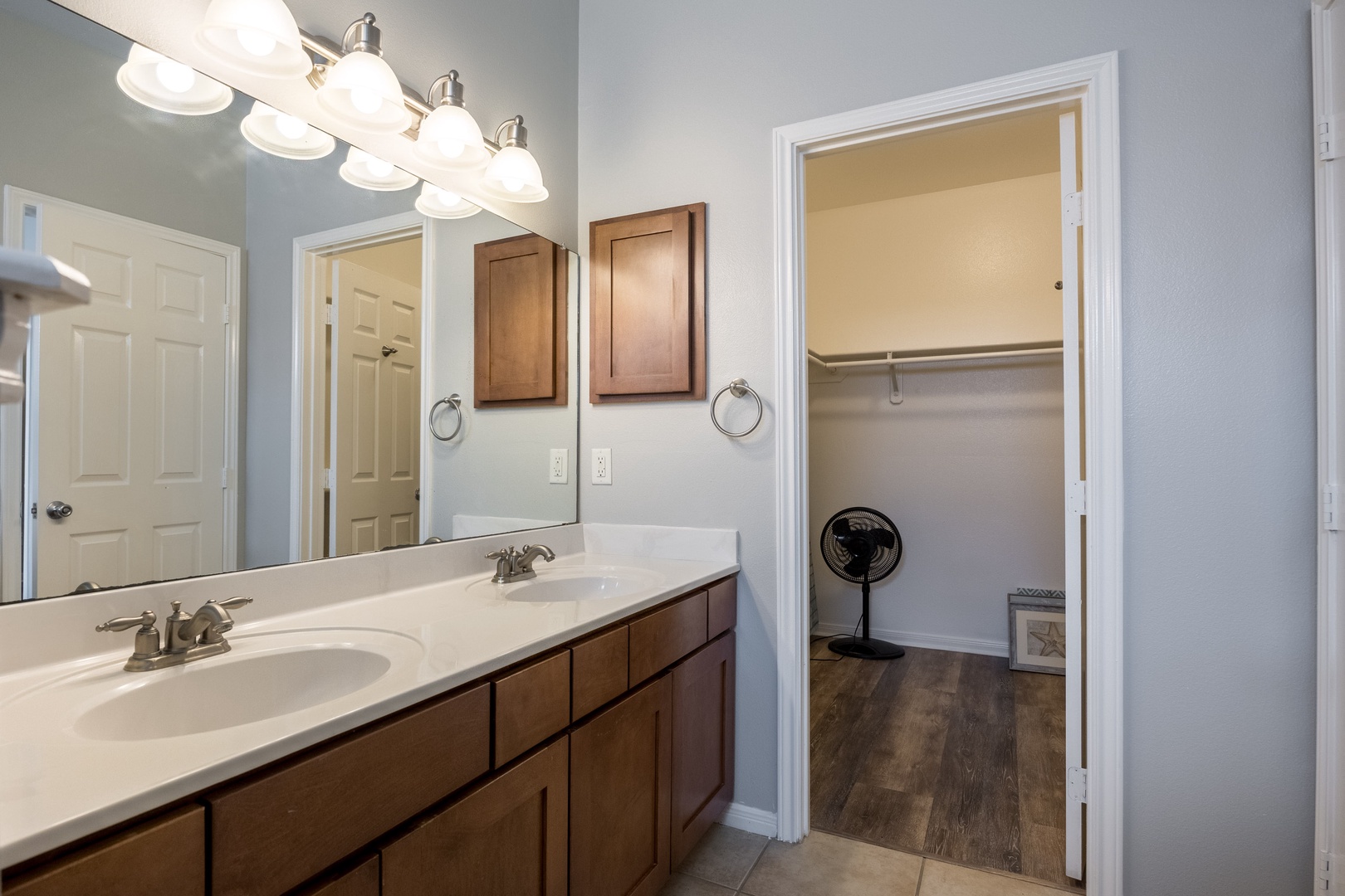 Ensuite bathroom with dual sinks, closet, and shower/tub combo