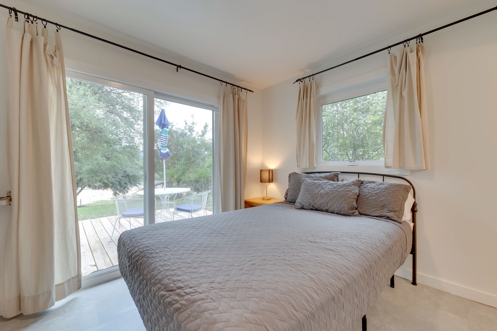 The 6th bedroom offers a queen bed, patio access, & private en suite