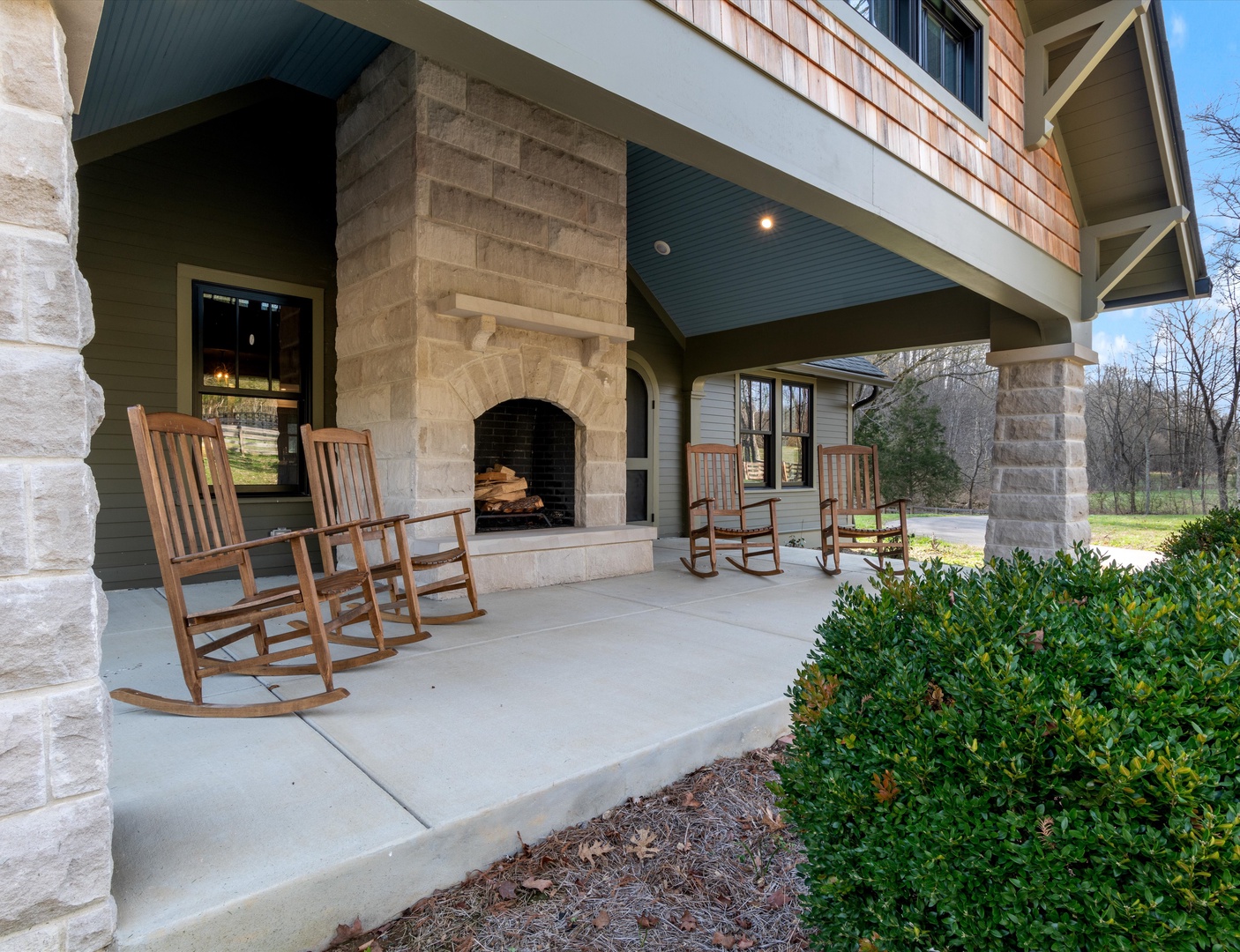 Front porch with rocking chairs, and outdoor fireplace