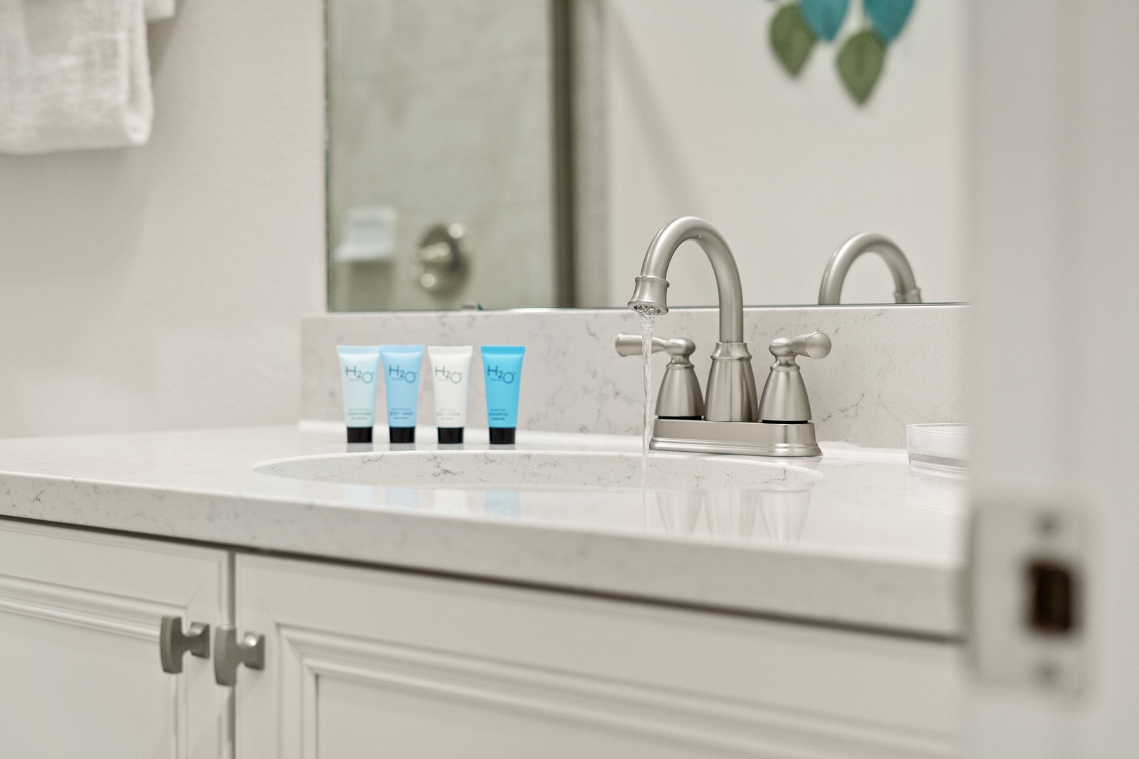 Shared bathroom with single vanity and glass-enclosed shower