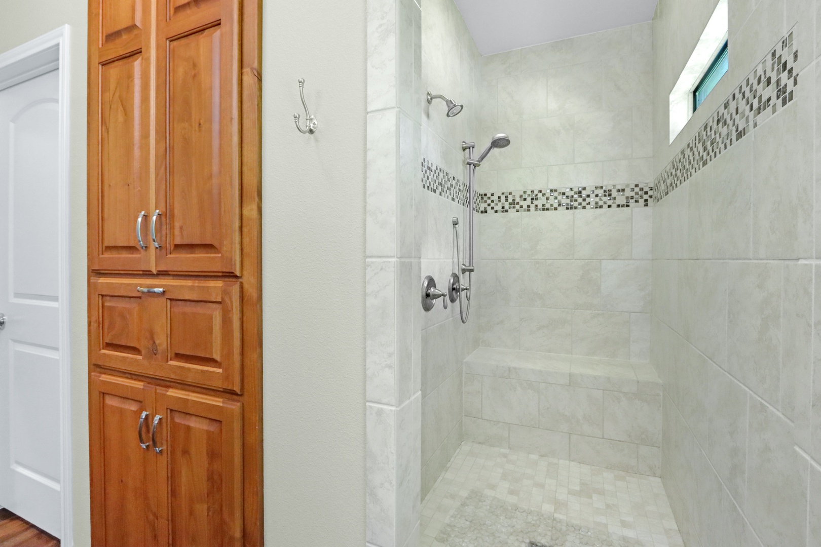 A double vanity & walk-in tiled shower await in this ensuite bath