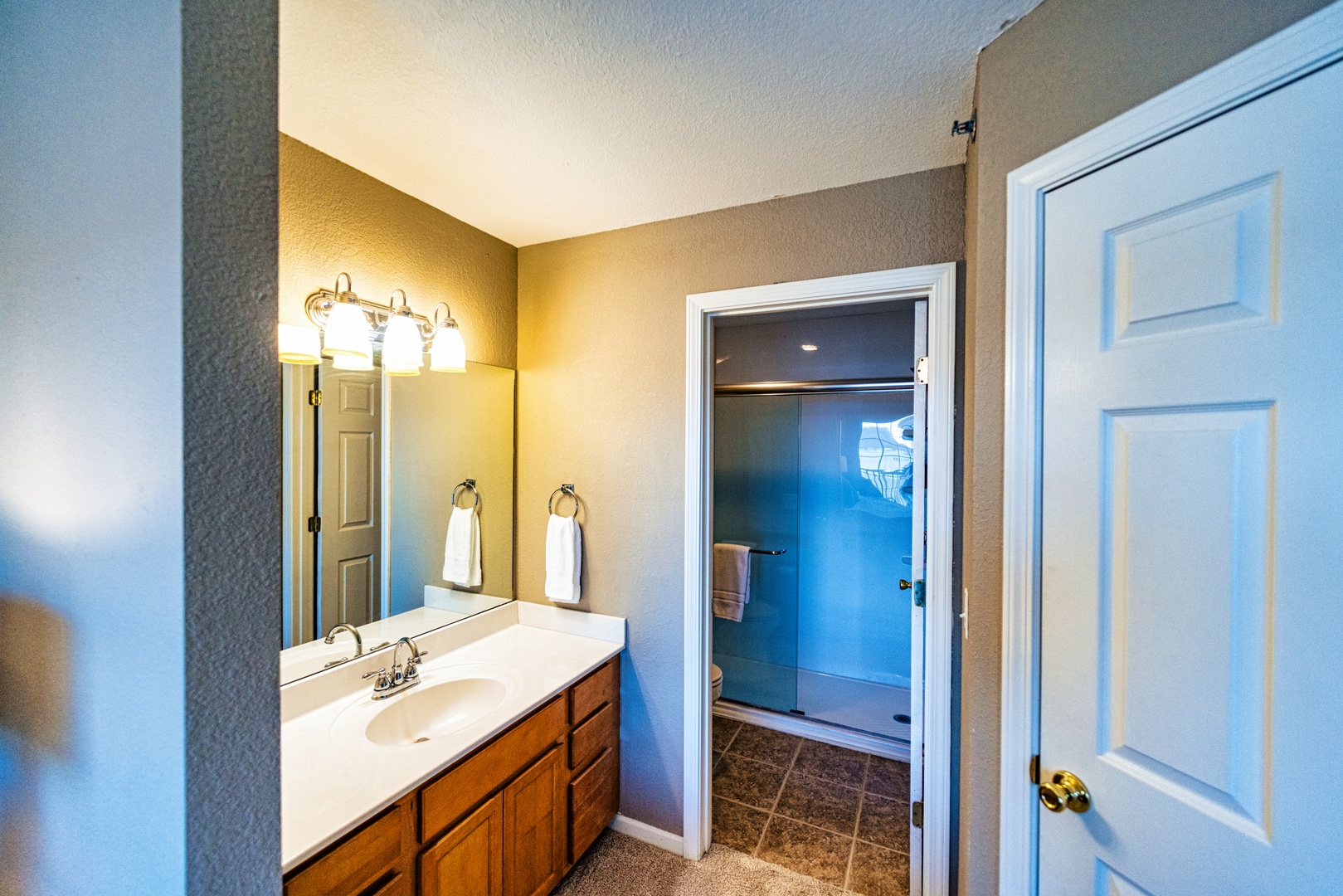 The king ensuite includes a single vanity, glass shower, & walk-in closet