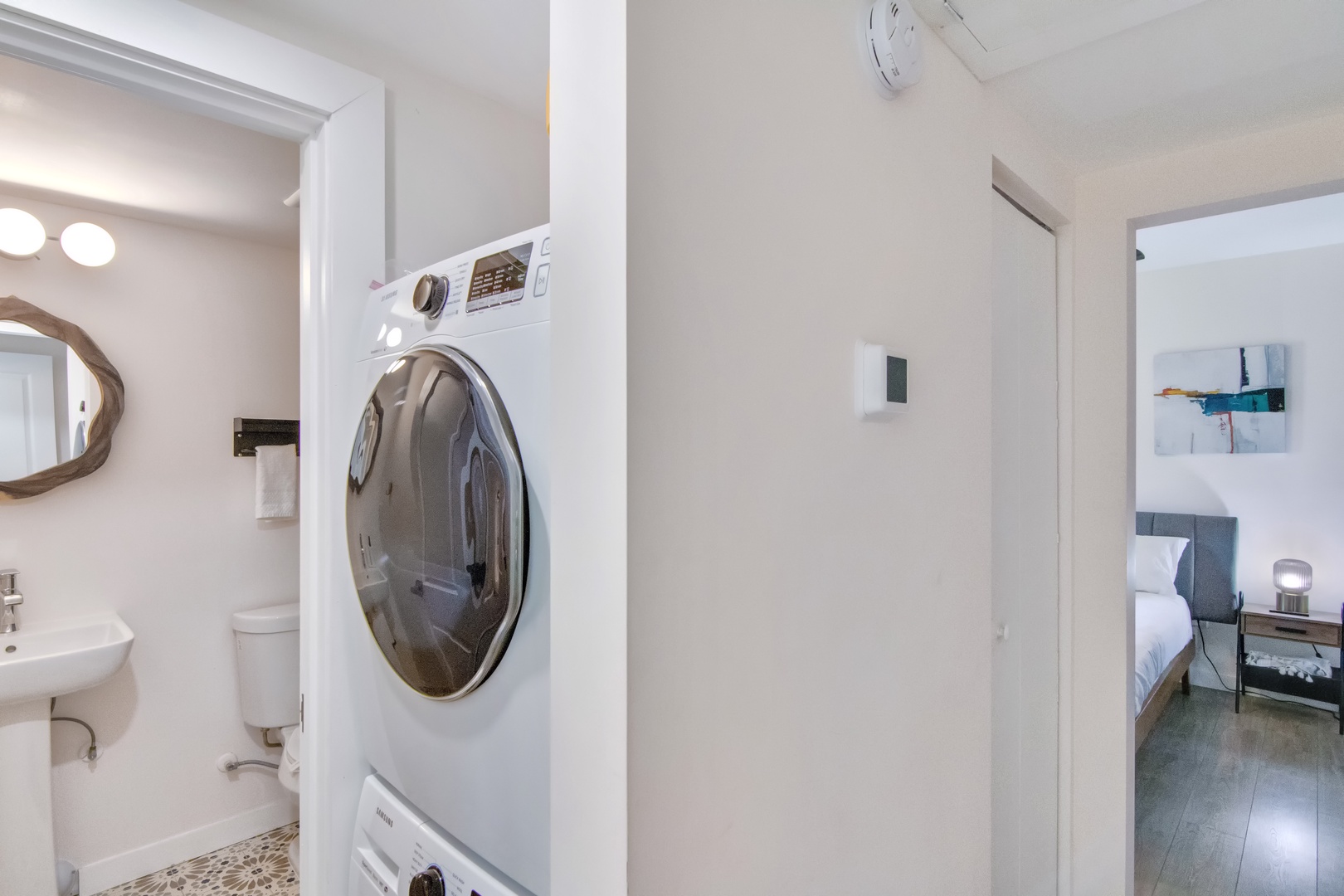 Hallway with stackable washer & dryer, and bathroom with shower/tub combo