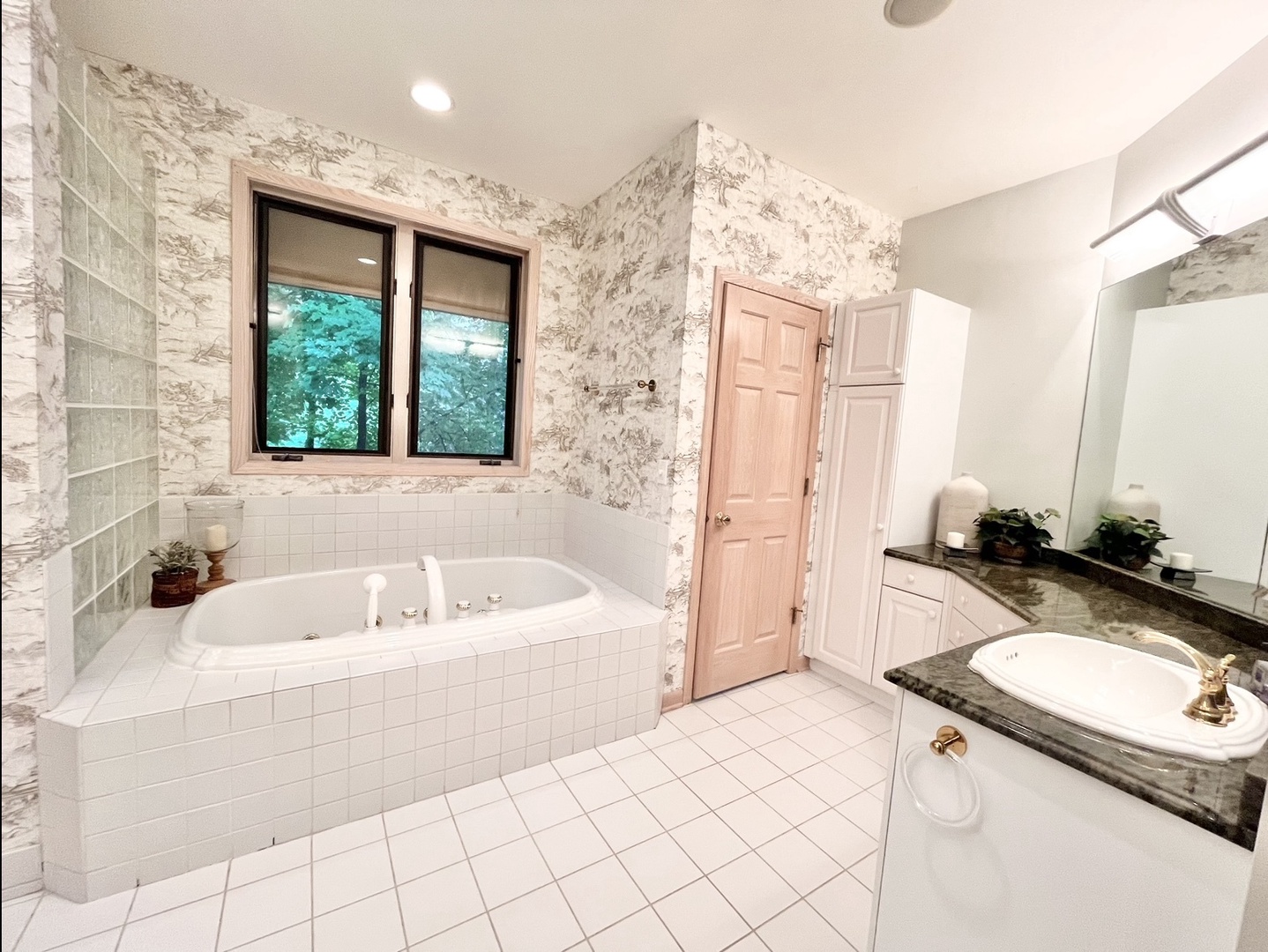 The main level en suite boasts a pair of vanities, glass shower, & soaking tub