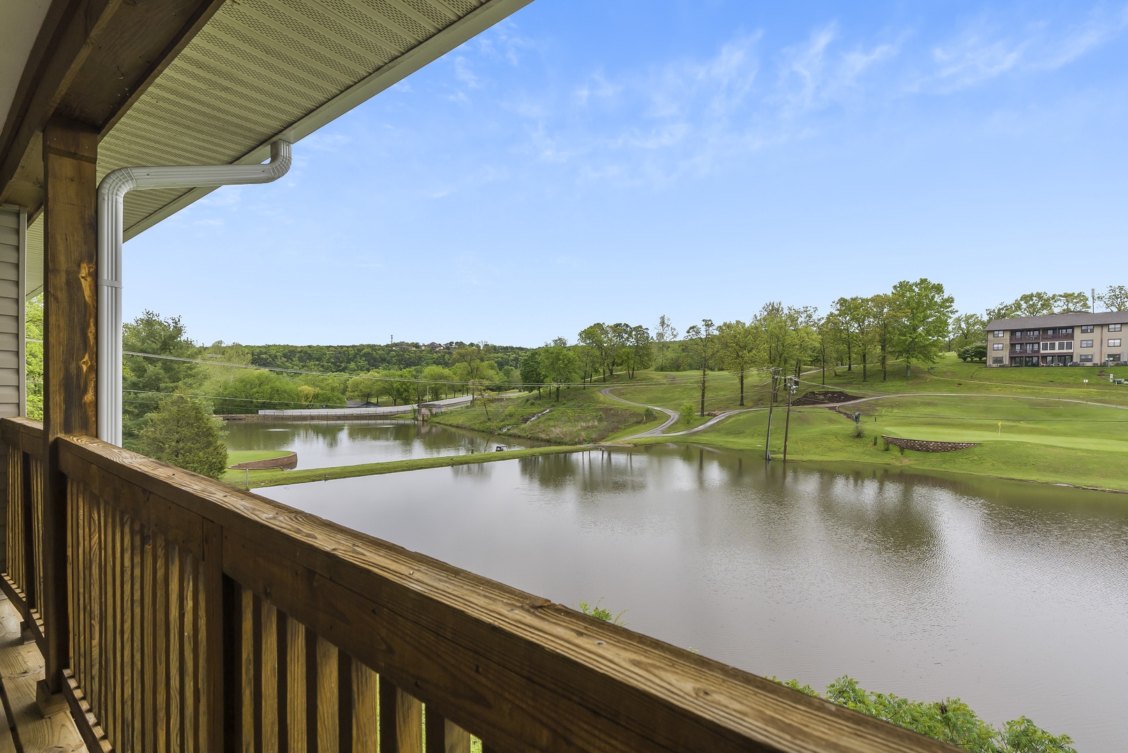 Balcony with outdoor seating, lake, and golf course view