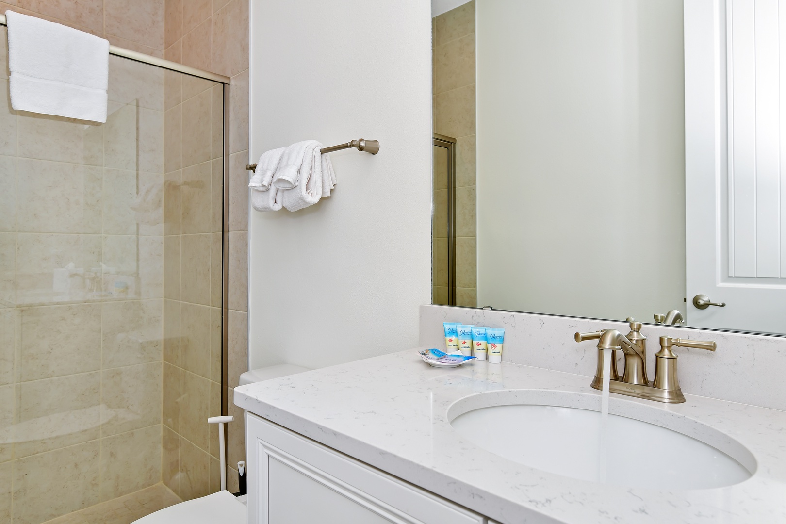 This charming bath features a single vanity & glass shower