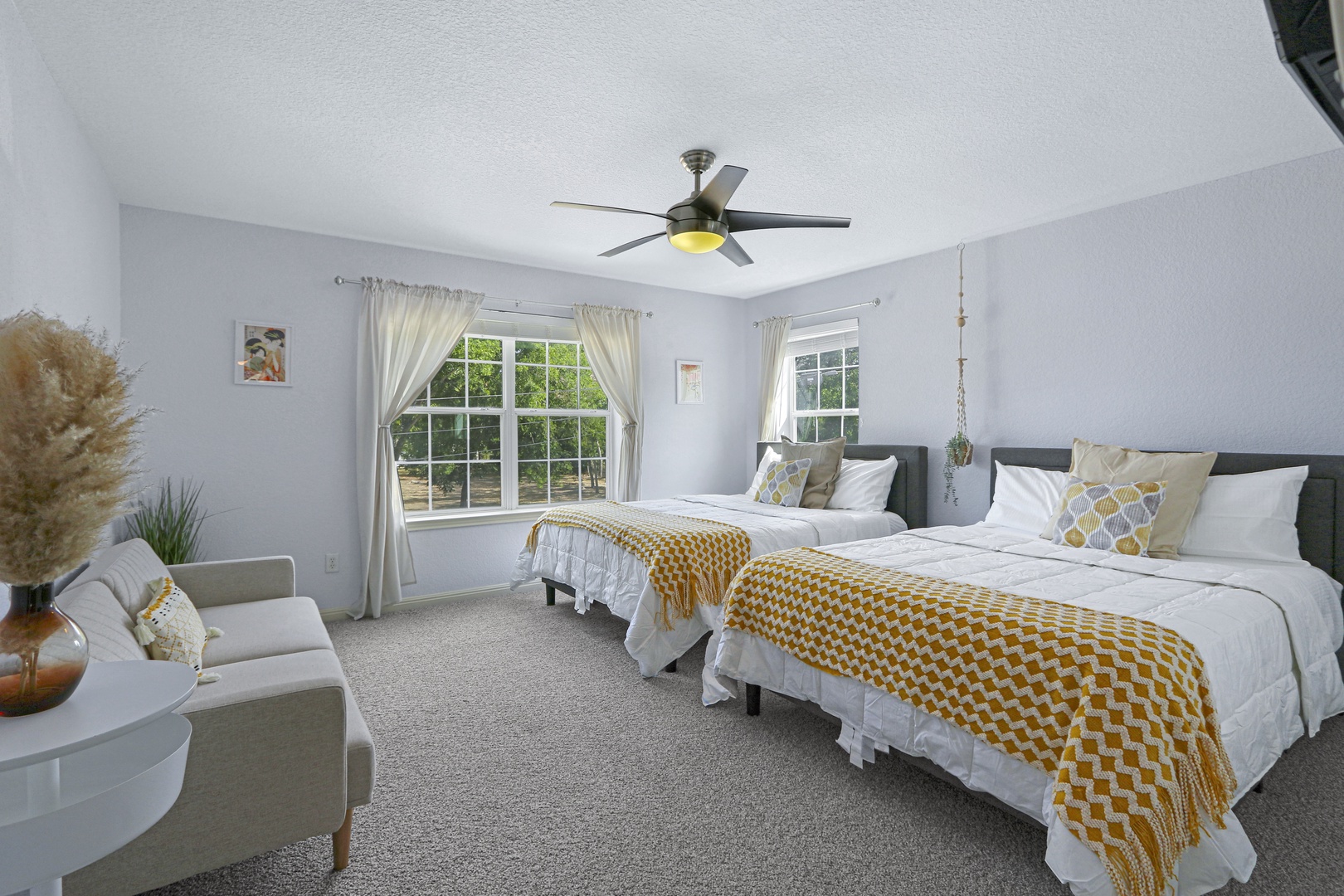 Bedroom 3 offers a pair of queen beds, Smart TV, & an additional cozy sofa