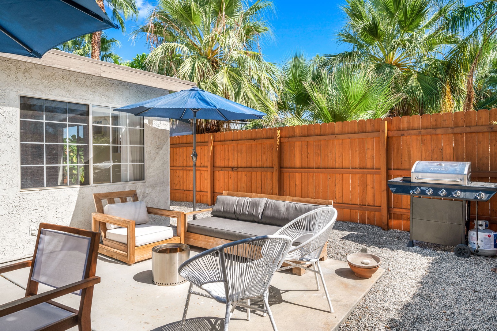 The fenced back yard offers space to lounge, grill, dine & play