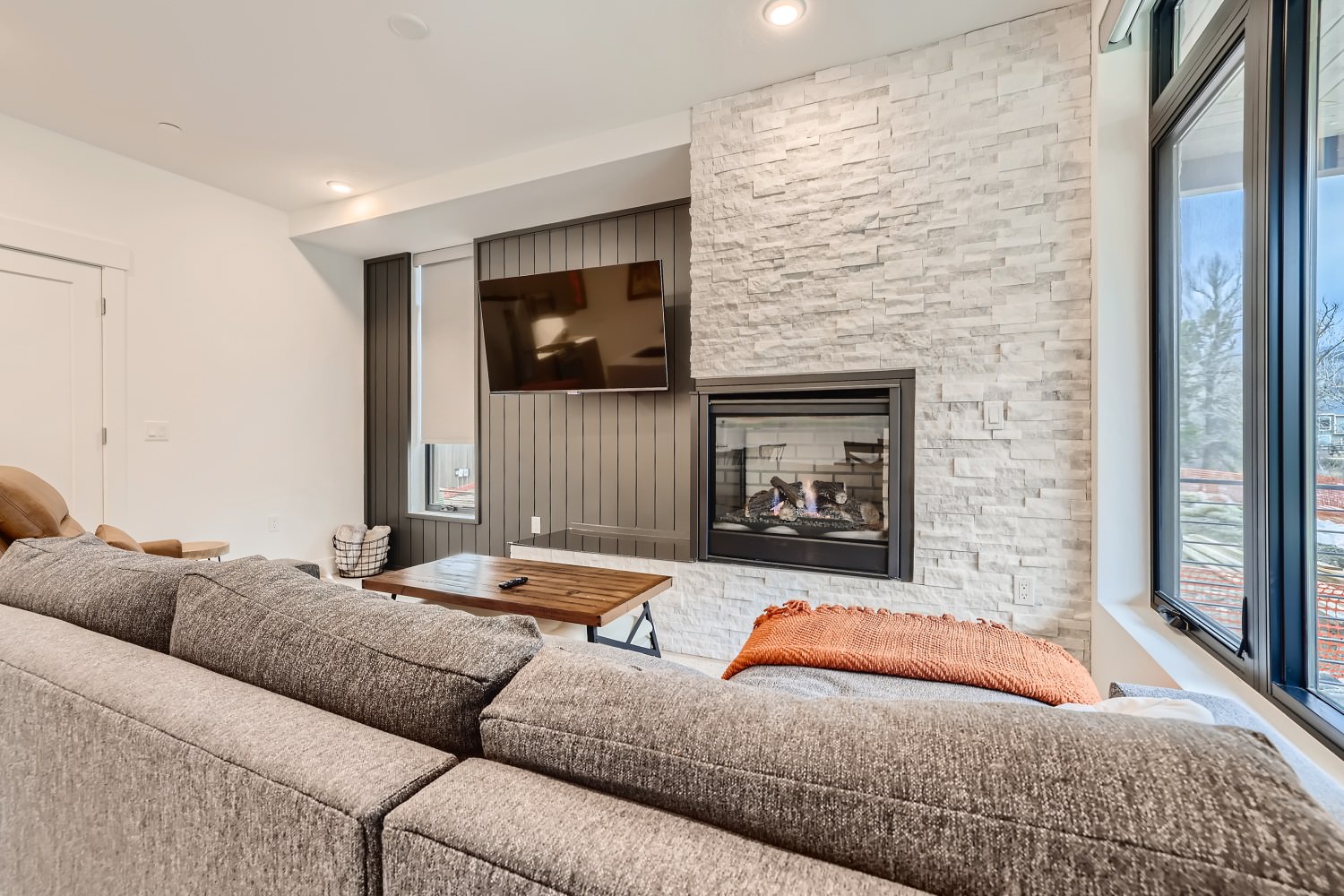 Open living space with gas fireplace, sofa sleeper, and Smart TV