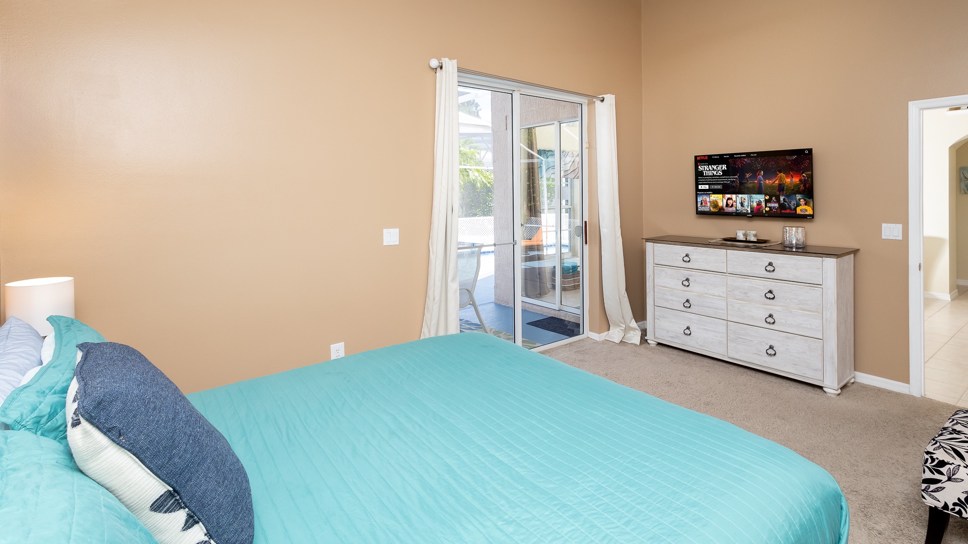 The king suite boasts a private ensuite, smart TV, & Patio/Pool lanai access