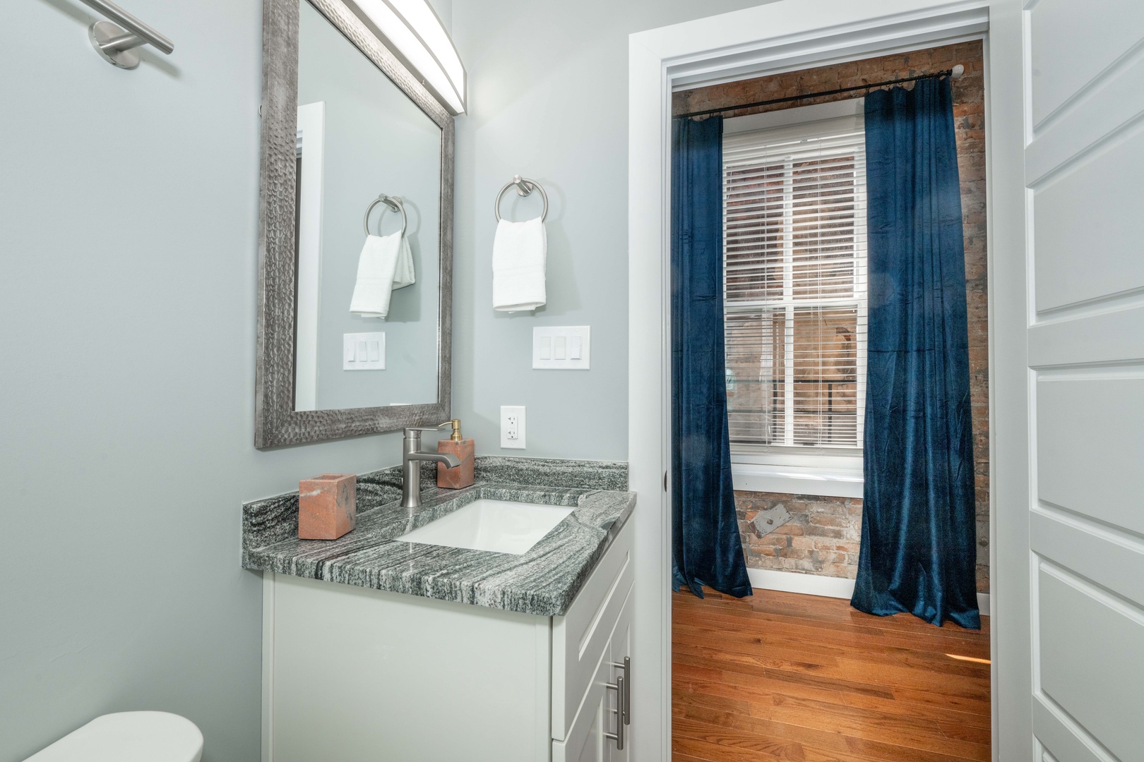 The sleek full bathroom offers a single vanity & shower/tub combo