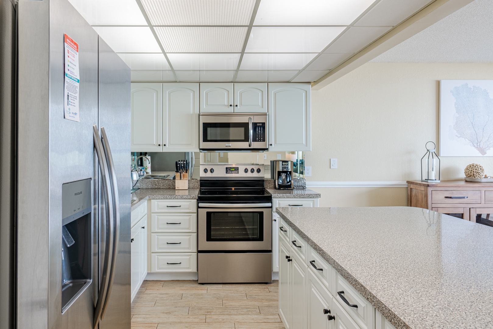 Galley kitchen with beautiful white cabinets and stainless steel appliances.