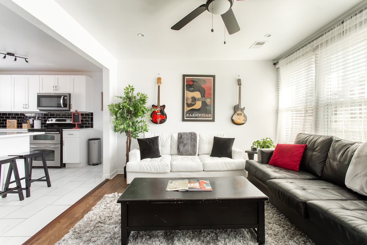 Modern living room with sofa sleeper, Smart TV, and music decor