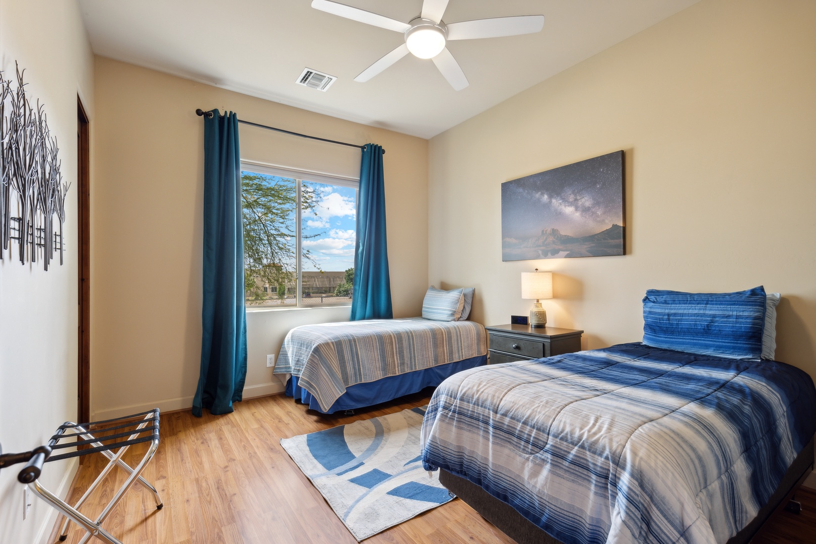 This bedroom includes a pair of twin beds, Smart TV, & ceiling fan