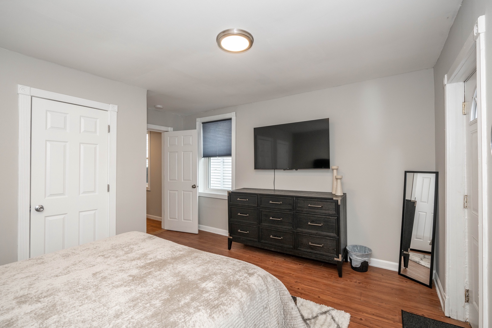 The first bedroom retreat boasts a plush queen bed, Smart TV, & balcony