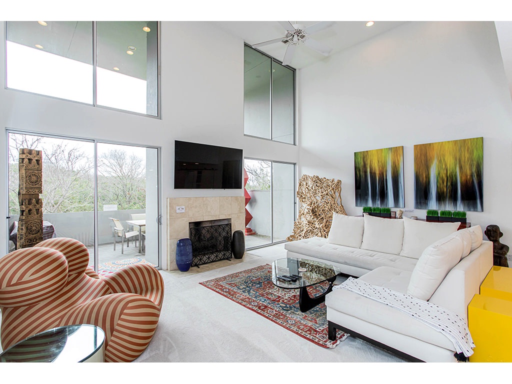 Mid level living room with TV, and large glass windows