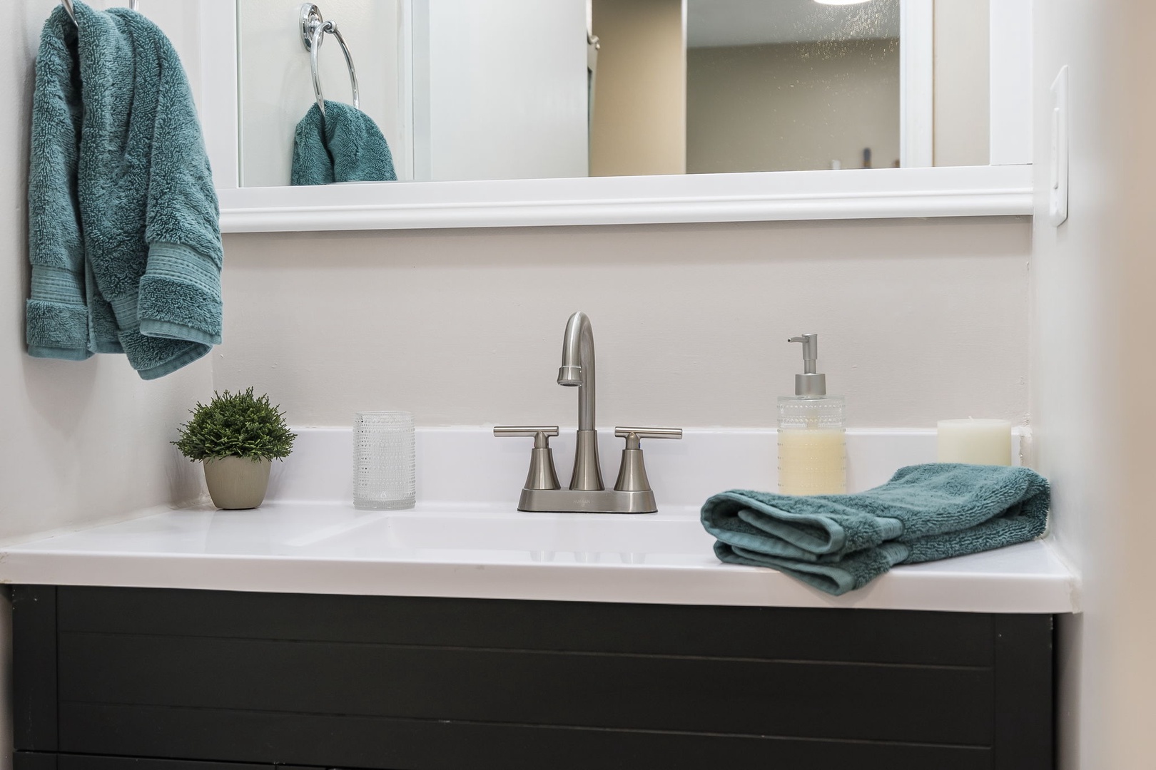 The chic bathroom contains a single vanity & shower/tub combo