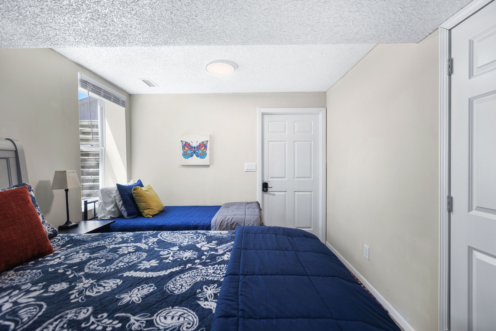 The lower-level bedroom offers a queen bed, a pair of twin beds, & Smart TV