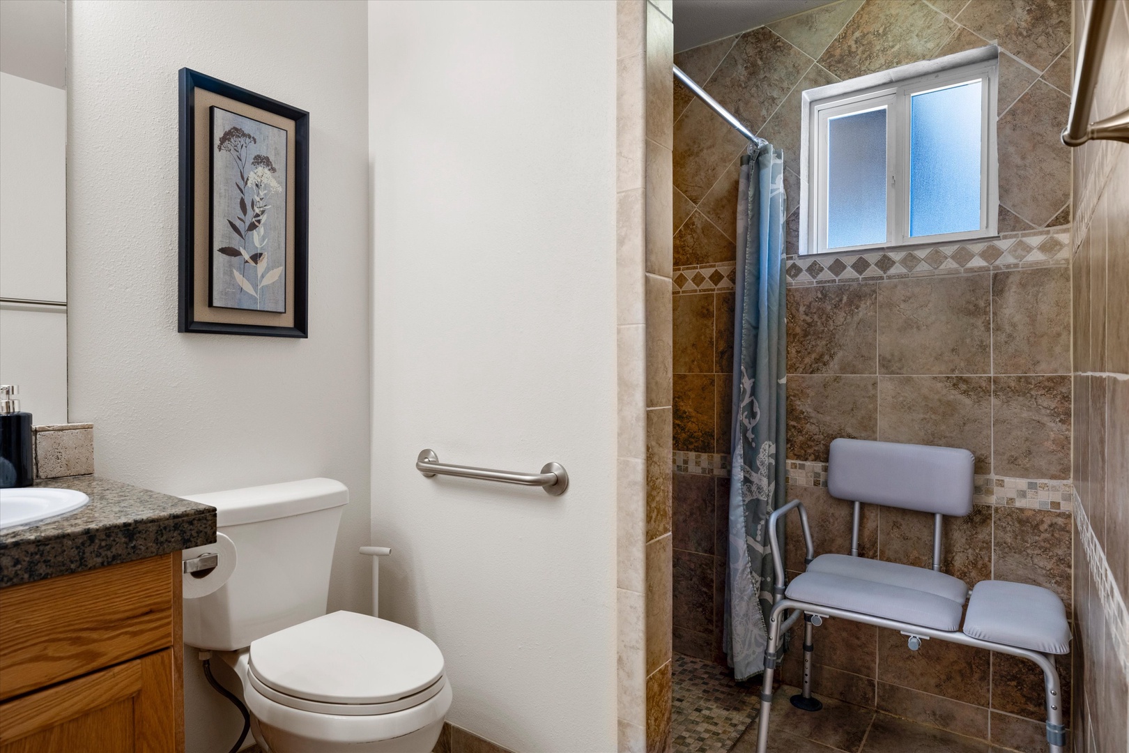 A single vanity & ADA-accessible shower await in the ensuite bath