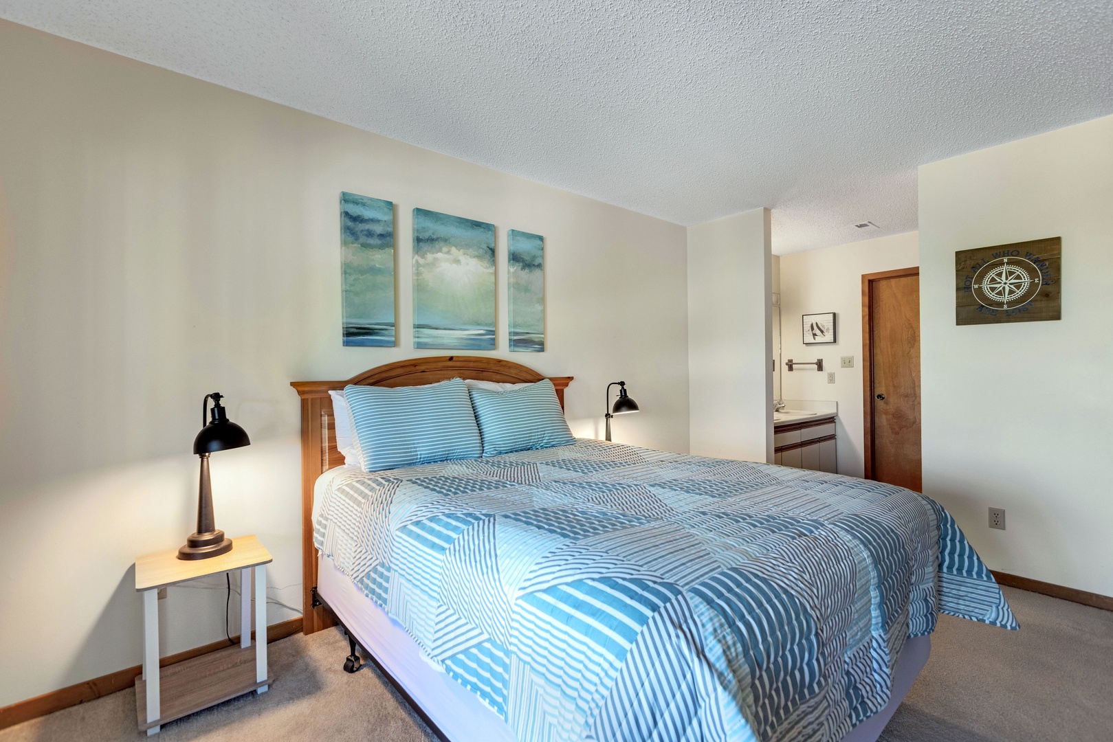 The primary bedroom offers a queen bed, deck access, & a private ensuite