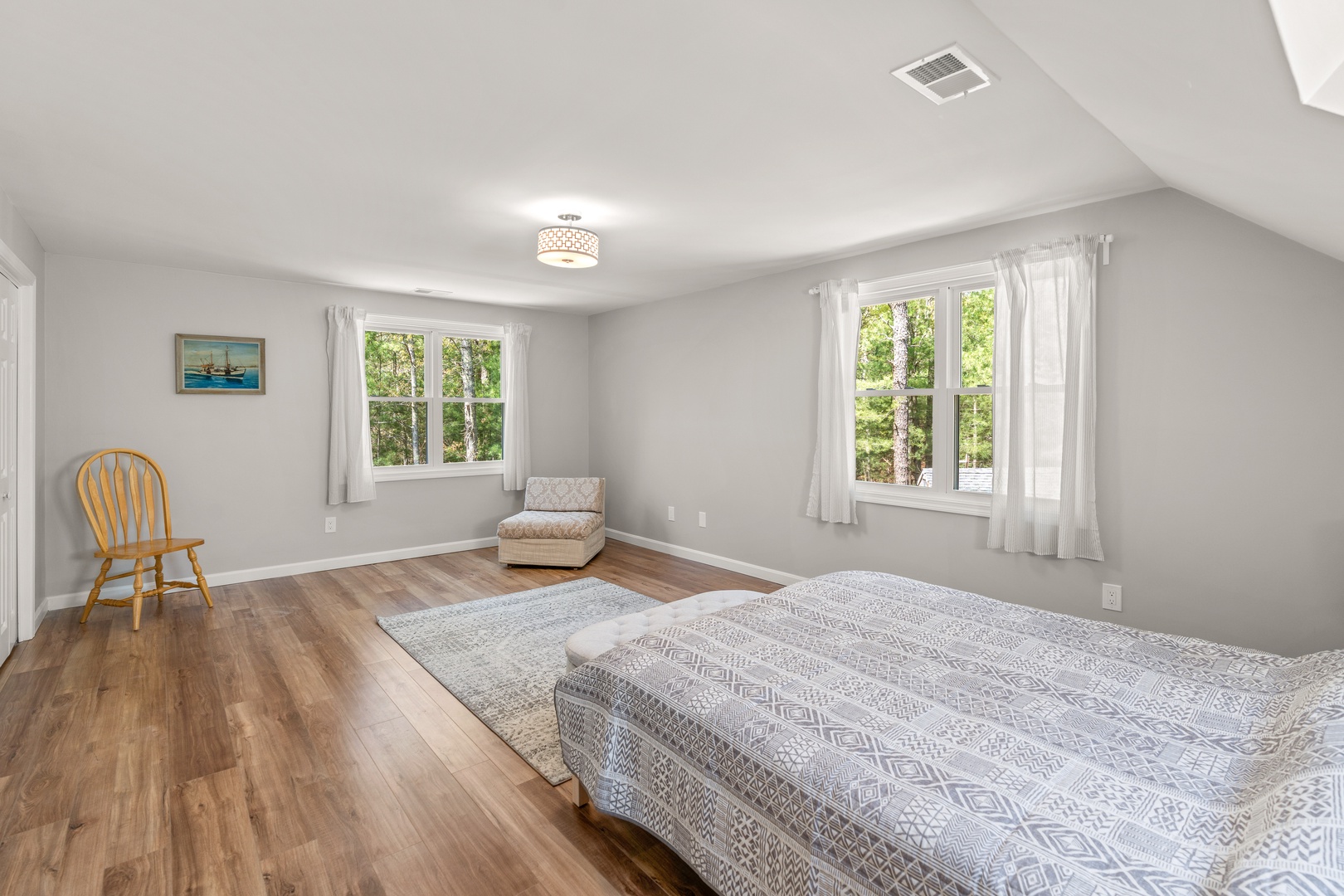 This light-filled bedroom on the 2nd floor offers a sleek queen-sized bed