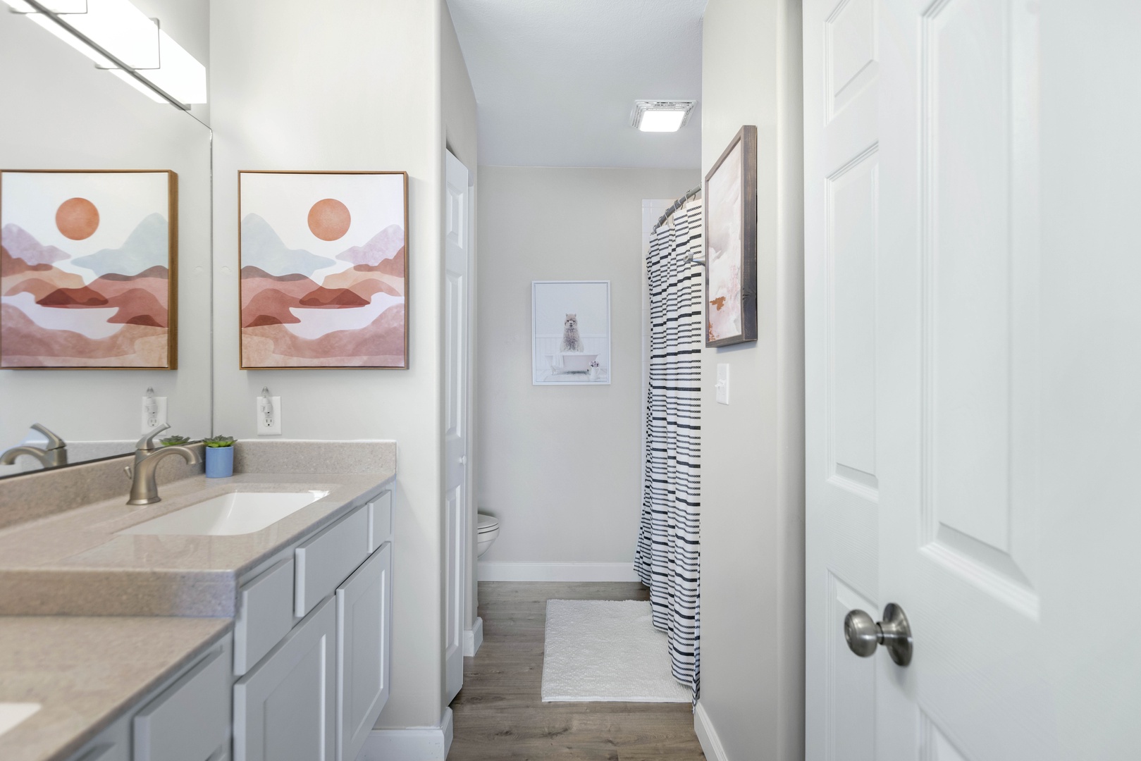 Ensuite bathroom with dual sinks and shower/tub combo