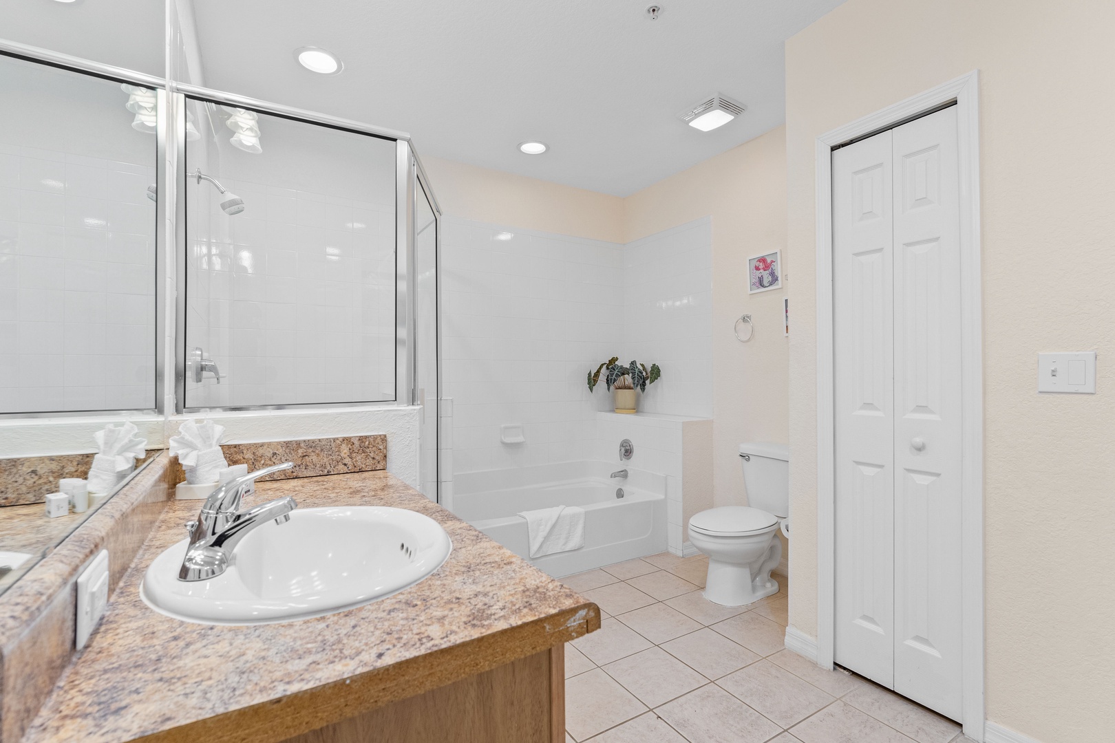 A single vanity, shower, & tub await in the shared ensuite bath