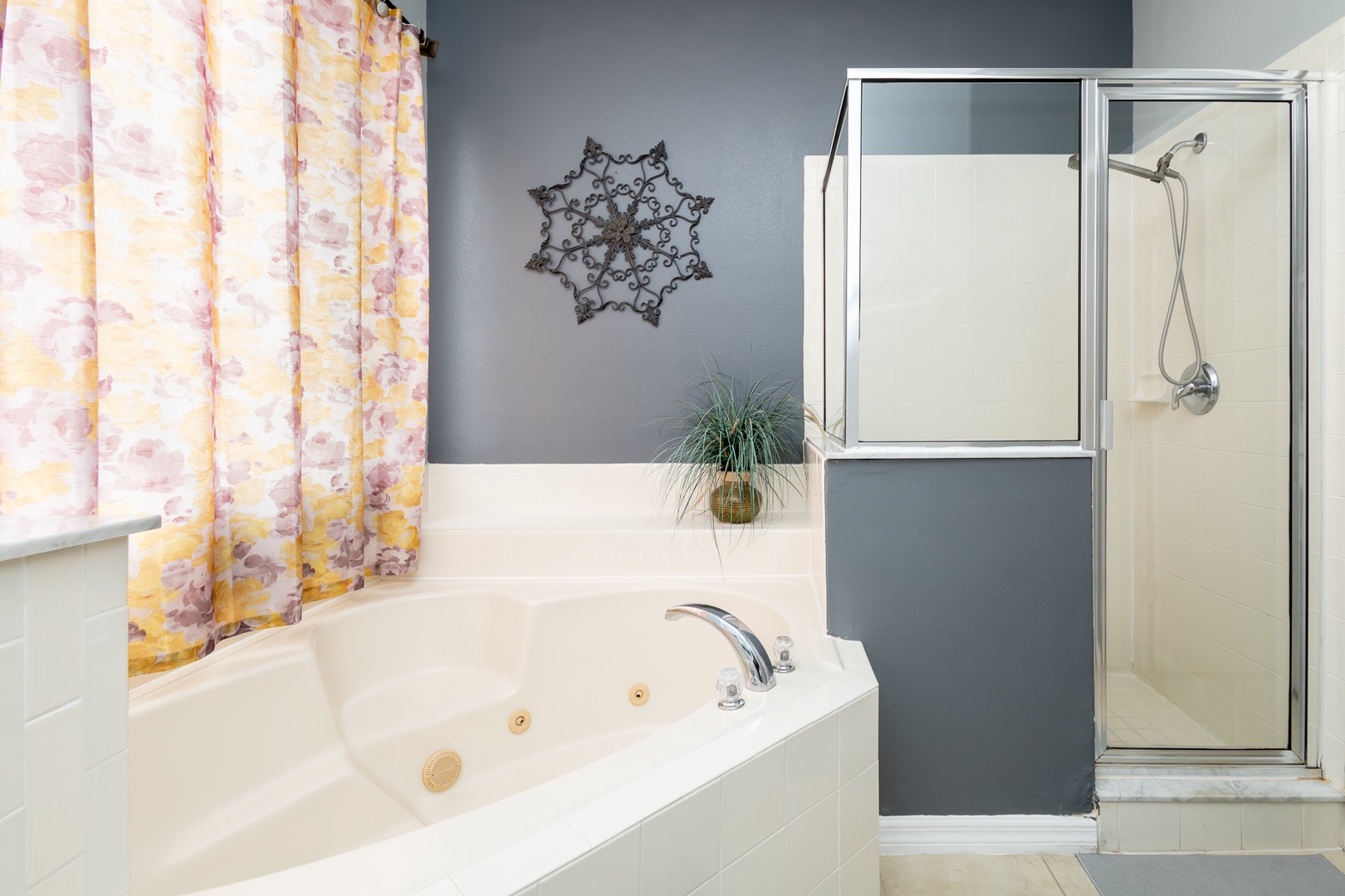 This ensuite bath features a double vanity, glass shower, and soaking tub