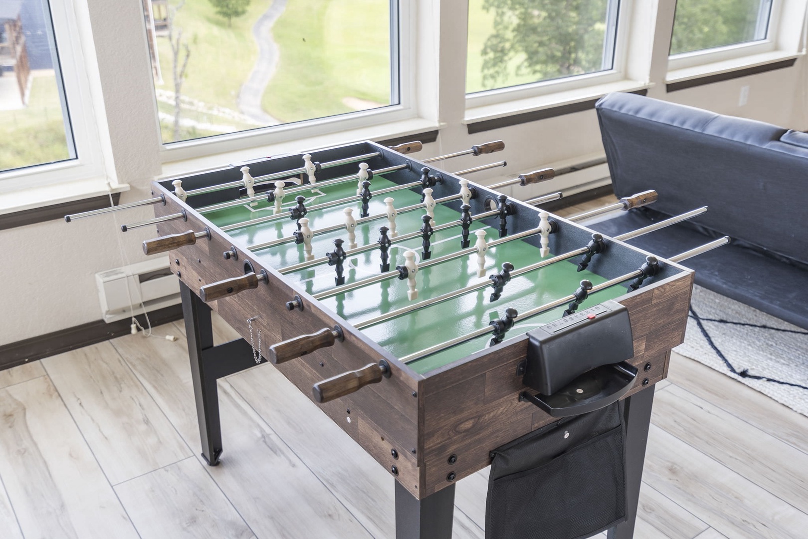 Bright sunroom with foosball, seating area, and TV