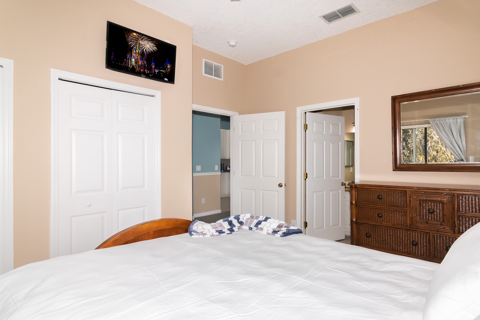 Master bedroom with Queen bed, TV, and en suite