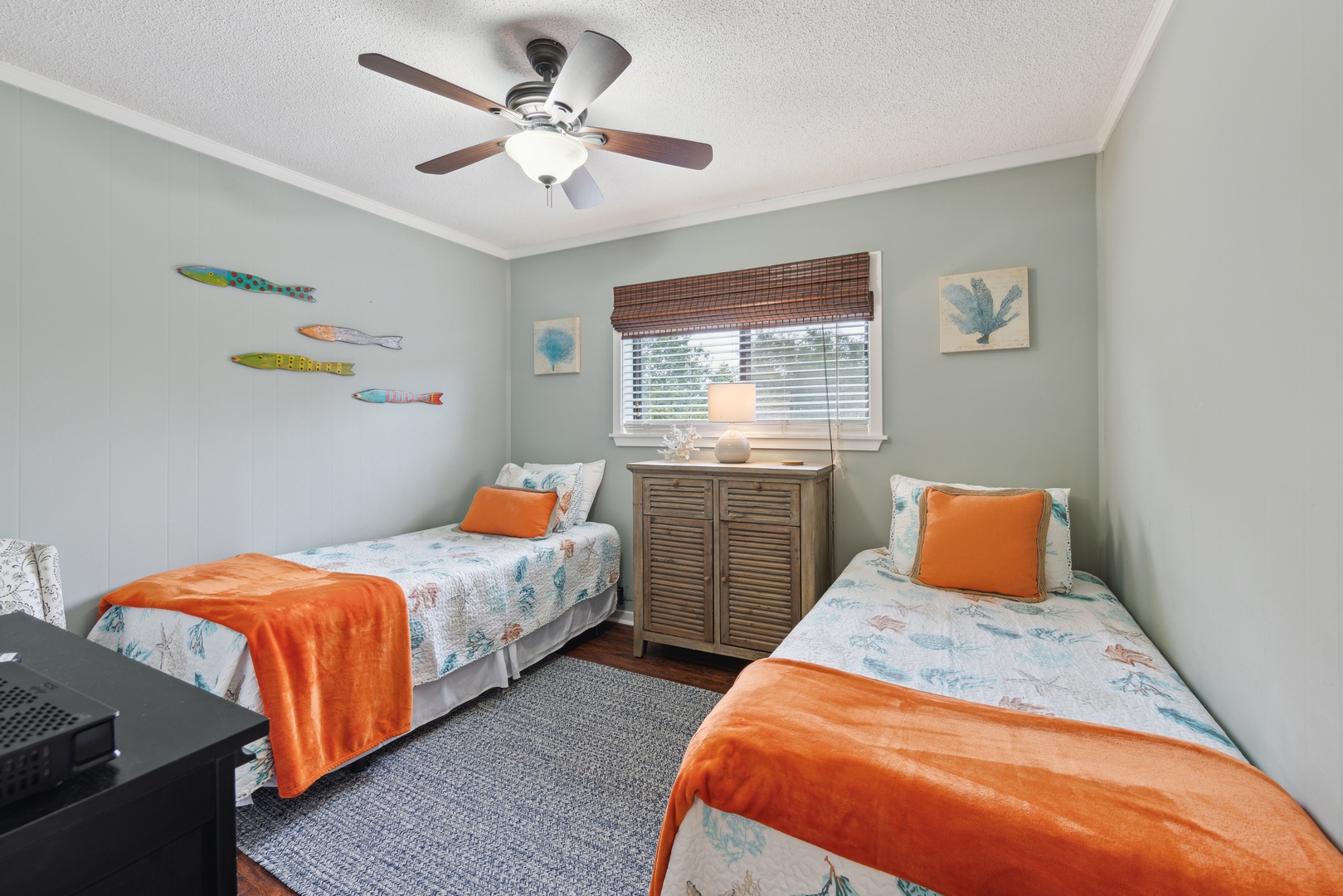 The 2nd comfy bedroom includes a pair of twin beds, TV, & ceiling fan