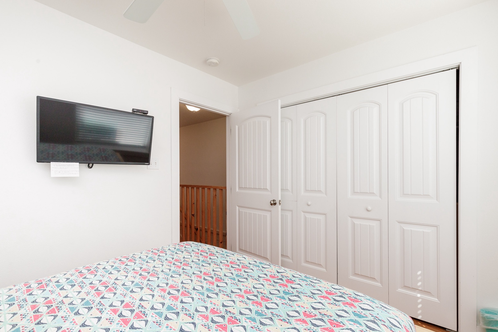 The final 2nd floor bedroom offers a queen bed, ceiling fan, & Smart TV
