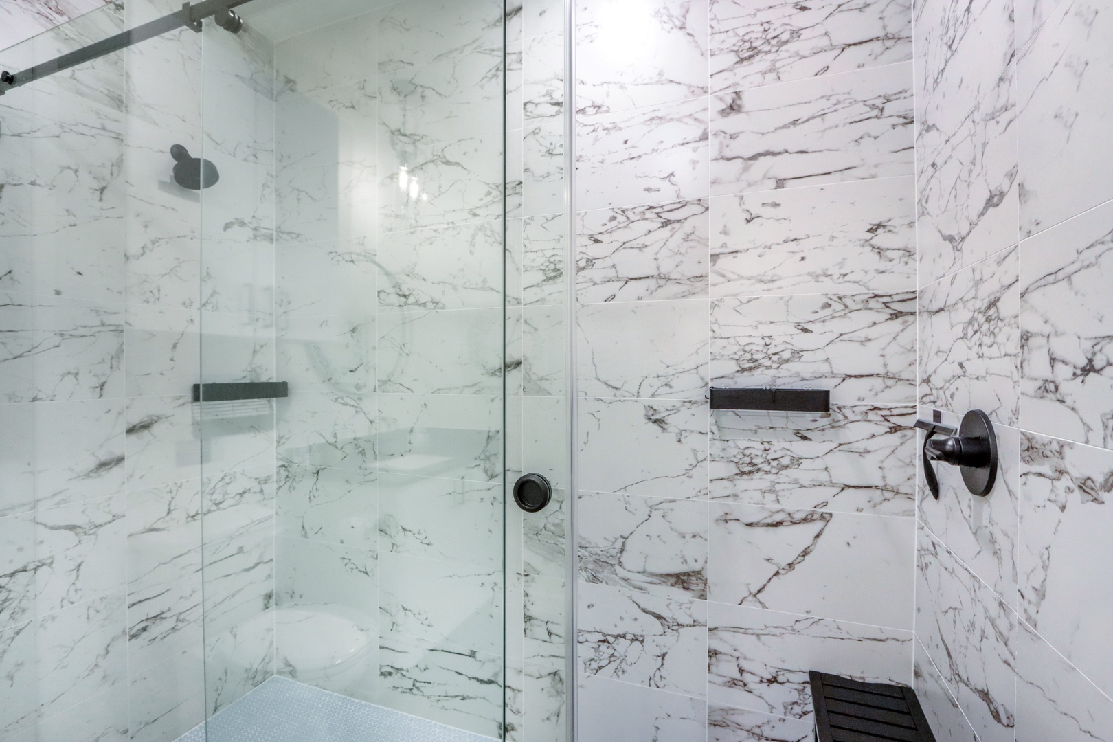 The sophisticated full bath includes a single vanity & glass shower