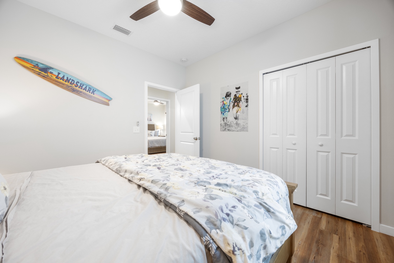 This bedroom features a plush queen-sized bed, with ceiling fan